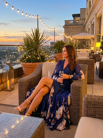 Zelina – abito maxi in chiffon blu navy, indossato seduta su una terrazza