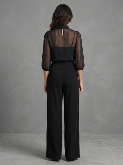Dalia — completo nero con blusa trasparente e pantalone a gamba larga, vista posteriore