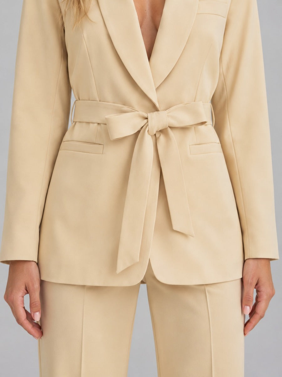 Genziana, dettaglio del blazer beige con cintura annodata a fiocco e tasche a filetto